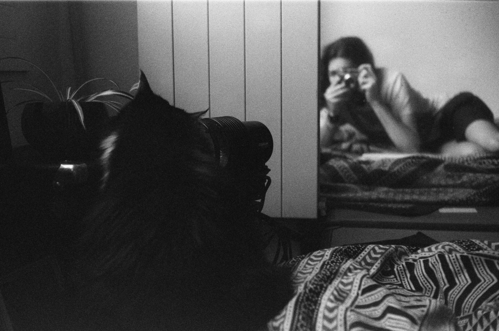 Autoportrait with a cat inside a room, on the Bed Black and white film.